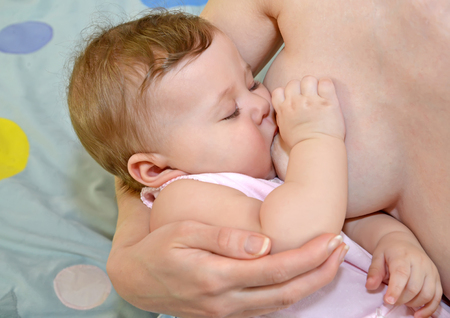 The baby sleeps at a maternal breast. Breastfeedingの写真素材
