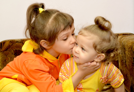 The girl kisses the younger little sister. Portraitの写真素材
