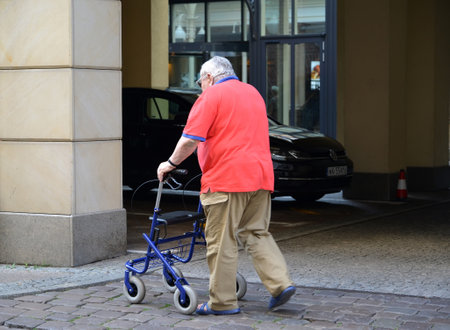GDANSK, POLAND - AUGUST 10, 2017: The elderly man with walkers support goes along the streetのeditorial素材