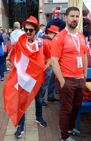 KALININGRAD, RUSSIA - JUNE 22, 2018: The emotional Swiss fan holds the flag of the country. Victory Square, Kaliningrad. The FIFA World Cup in Russiaのeditorial素材