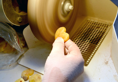 Treatment of amber workpiece on polishing machine. Jewelry workshop