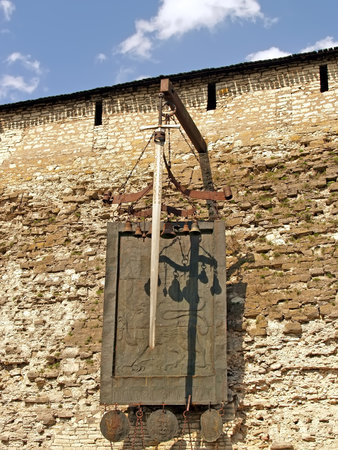 PSKOV, RUSSIA - MAY 08, 2010: Coat of arms and sword on the wall of the Pskov Krom (Kremlin). Russian text - Whoe comes with a sword will perish by the swordのeditorial素材