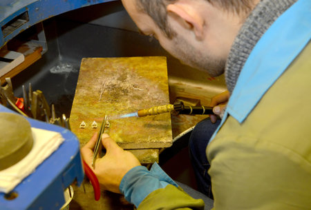 KALININGRAD, RUSSIA - JANUARY 23, 2019: Jeweller works with gas soldering iron in workshopのeditorial素材