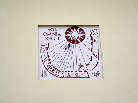 FROMBORK, POLAND - JULY 09, 2015: A solar watch on the wall of a building reading in Latin sol omnia...