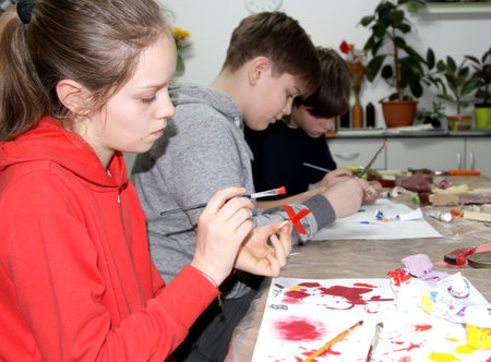 KALININGRAD, RUSSIA - JANUARY 26, 2020: Pupils paint the details of a wooden ship. Children 's master class in the studioのeditorial素材