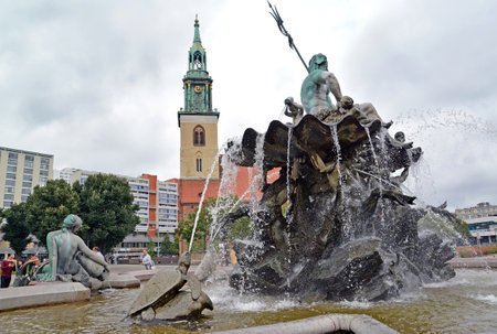 BERLIN, GERMANY - AUGUST 12, 2017: Fragment of the Neptune Fountain on the background of the Church of St. Nicholasのeditorial素材