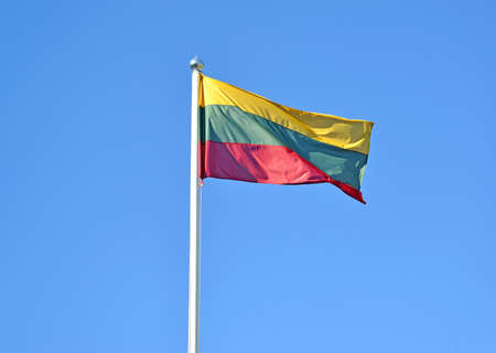 The national flag of Lithuania flies against the background of the blue skyの写真素材