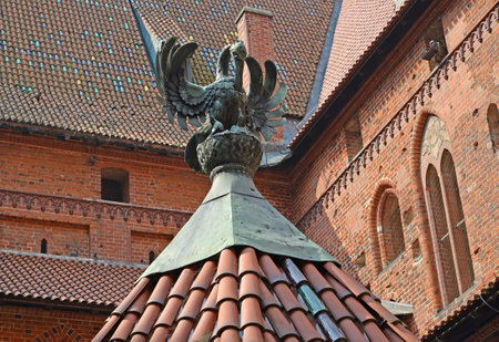 Sculpture of a pelican feeding chicks. The roof of the well on the territory of the High Knight's Castle of the Teutonic Order. Malbork, Polandのeditorial素材