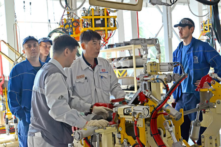 KALININGRAD, RUSSIA - SEPTEMBER 16, 2014: Korean specialists show Russian workers the device of new...