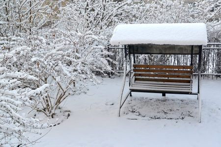Suspension bench and bushes after snowfall. Winterの写真素材