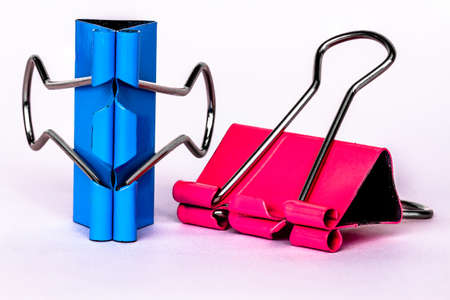 Two pink and blue metallic paper clips, isolated on a white background, for a cheerful office, work, school and business conceptの写真素材