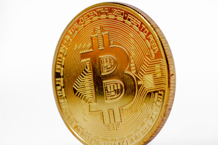 Front view of bitcoin with slightly tilted composition, has a gold color isolated on white background, for payment, investment, finance and economy conceptの写真素材