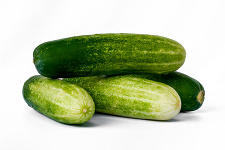 Four cucumbers for greens, in a stack composition, isolated on a white background, copy spaceの写真素材