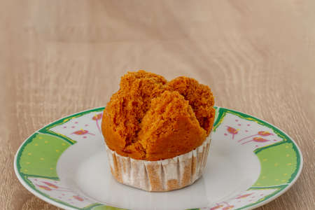 A sponge cake on a small plate for breakfast and a friend to drink coffee, wood backgroundの写真素材