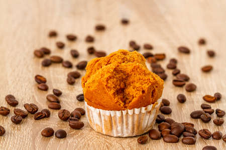 A sponge cake on a small plate for breakfast and a friend to drink coffee, wooden board background and coffeeの写真素材