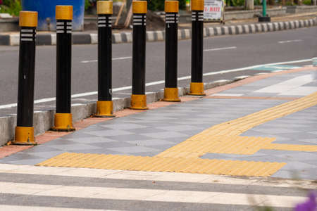 The sidewalk next to the highway is equipped with a path for people with disabilities in yellow, the concept of equal rightsの写真素材