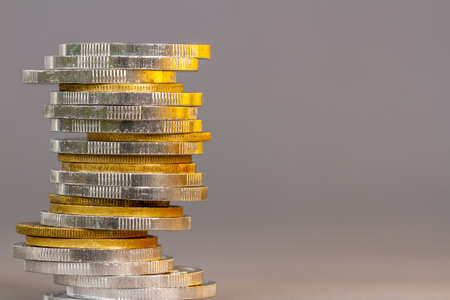 A pile of used gold coins mixed with silver, background blur, financial conceptの写真素材