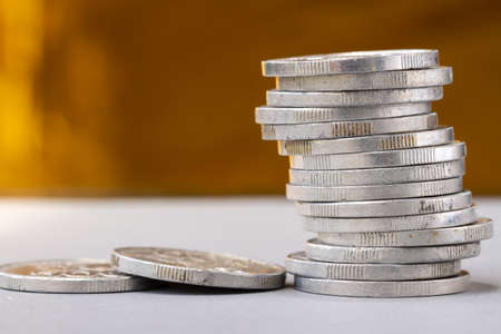 A pile of used silver coins, background blur, financial conceptの写真素材