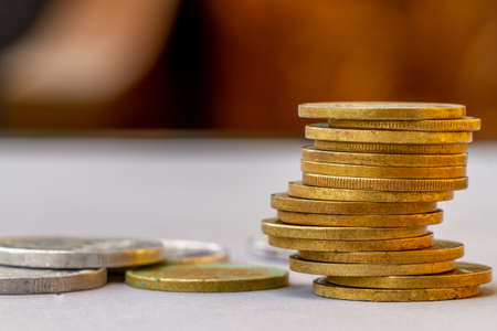 A pile of used gold coins, background blur, financial conceptの写真素材