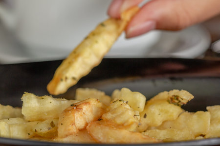 French fries served on a black ceramic plate, a snack for lunch