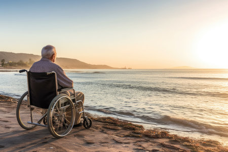 A person is sitting in a wheelchair on a beach, enjoying the natural sceneryの素材