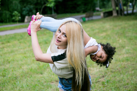 Happy mother holds her daughter. Happy mother playing with daughter at parkの写真素材