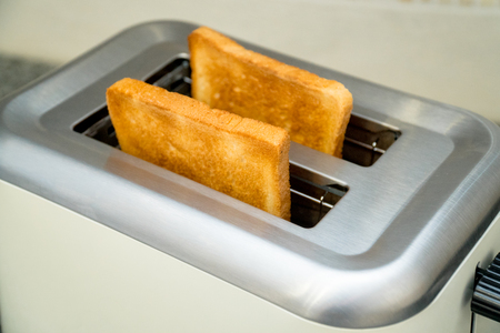 Toaster with toasted bread for breakfast insideの写真素材