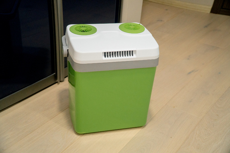 Green portable refrigerator for drinks on wooden backgroundの写真素材
