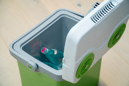 Green portable refrigerator with drinks food on wooden backgroundの写真素材