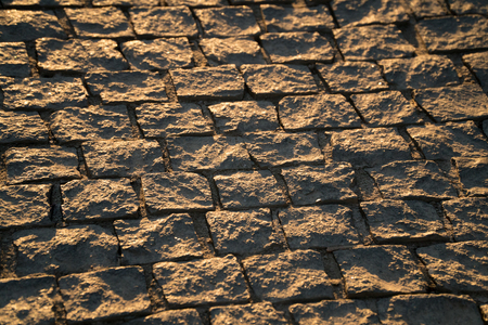 Old pavement of granite. Brown square cobblestone sidewalk. Sunsetの写真素材