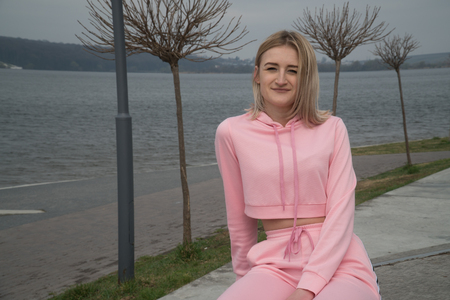 Happy young athletic girl in pink by the lake. Girl on the runの写真素材