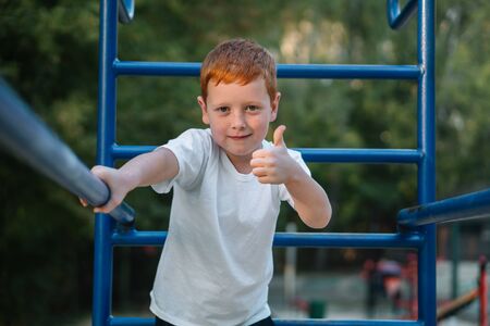 Little boy playing sports on street public sports simulatorsの写真素材