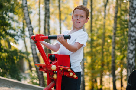 Little boy playing sports on street public sports simulators