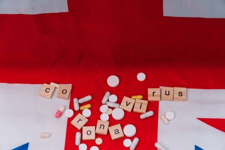 Mixed pills on UK flag with the inscription coronavirus. Coronavirus in the UK. Victory over coronavirus. Covid-19 vaccineの写真素材