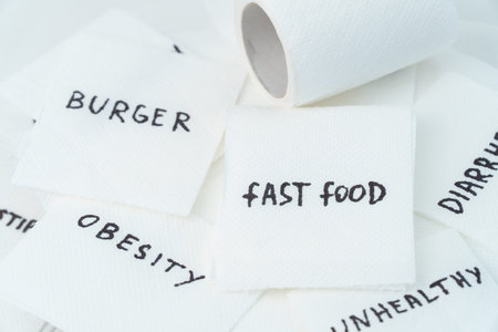 Toilet paper with text fast food in wc. Concept of personal hygiene. Fast food Concept