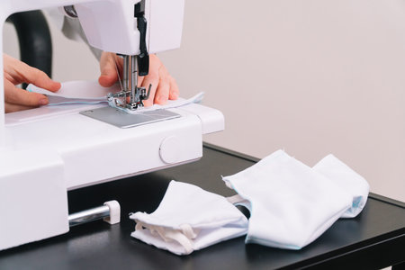 Woman sews a protective mask. Making cotton fabric medical mask, coronavirus protection. Quarantine...