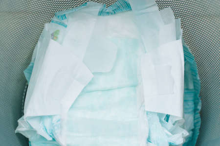 Disposing of used nappies in trash. Concept of child care. Pollution of environmentの写真素材