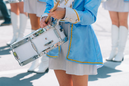 Young girls drummer at the parade. Street performance. Majorettes and marching band