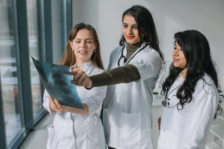 Three women doctors of different races analyze the X-rayの写真素材