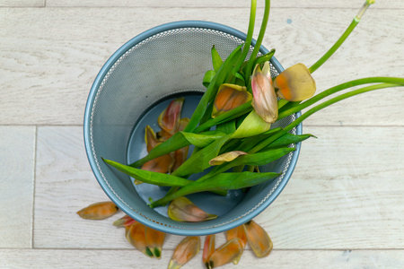 A bouquet of flowers in the trash can. Woman throws out a bouquet of flowers. Reverse speed. Ecology...