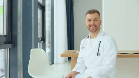A friendly doctor invites a patient for a consultationの写真素材