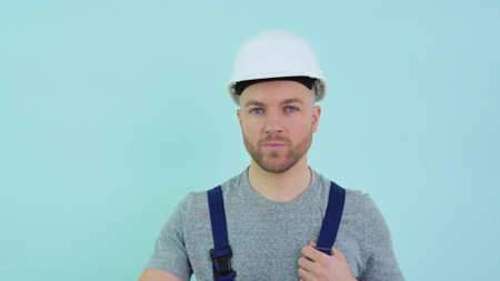 Serviceman in overalls putting on a helmetの写真素材