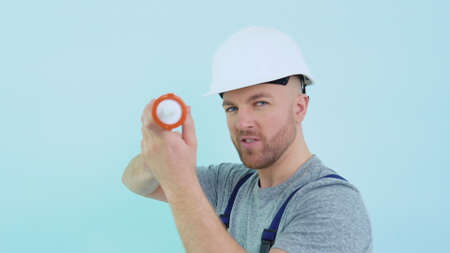 Repairman in overalls holding silicone adhesiveの写真素材