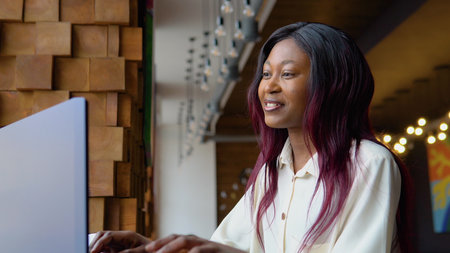 Video chat job interview or distance language course class concept. African woman communicating by conference call speak looking in laptopの写真素材