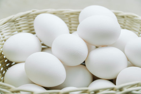 Raw white chicken eggs in a basket top view