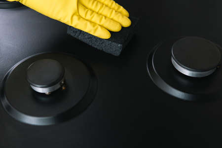 Close up of woman cleaning gas stove at home kitchen. Cleaning and tidying the household gas stoveの写真素材