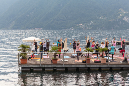 Lugano - June 23, 2013 - People doing Yoga exercise on Lugano lake in the morning on June 23, 2013のeditorial素材