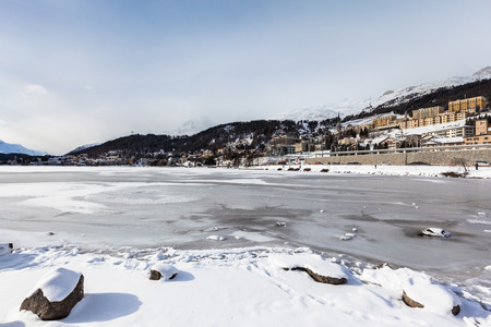 View of the icy Sankt Moritz lake and the city on the mountain in Winter, Grisons, Switzerlandのeditorial素材