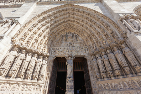 Entrance of Notre Dame with lots of relief sculptures in Paris, Franceの写真素材