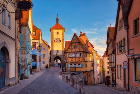 Symbolic view of the medieval old town Rothenburg ob der Tauber at Ploenlein before sunset with beautiful golden sunlight falling on the historical building, Bavaria, Germanyの写真素材